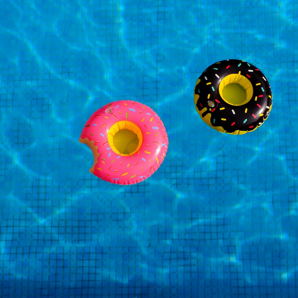 two inflatable donuts floating in a swimming pool
