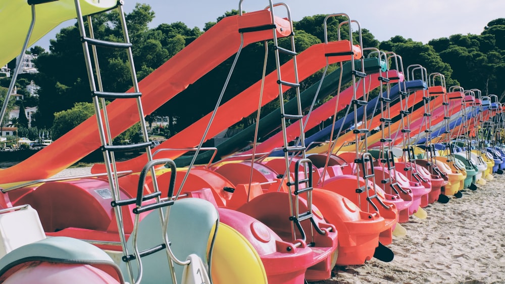 a row of brightly colored beach chairs sitting on top of a sandy beach
