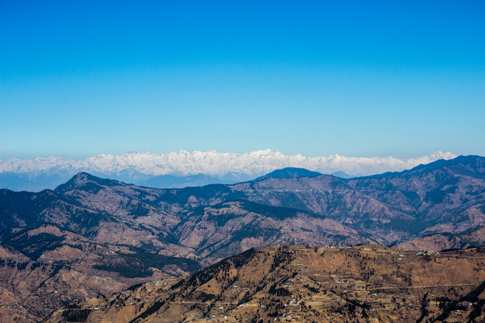 a view of a mountain range with snow capped mountains in the distance