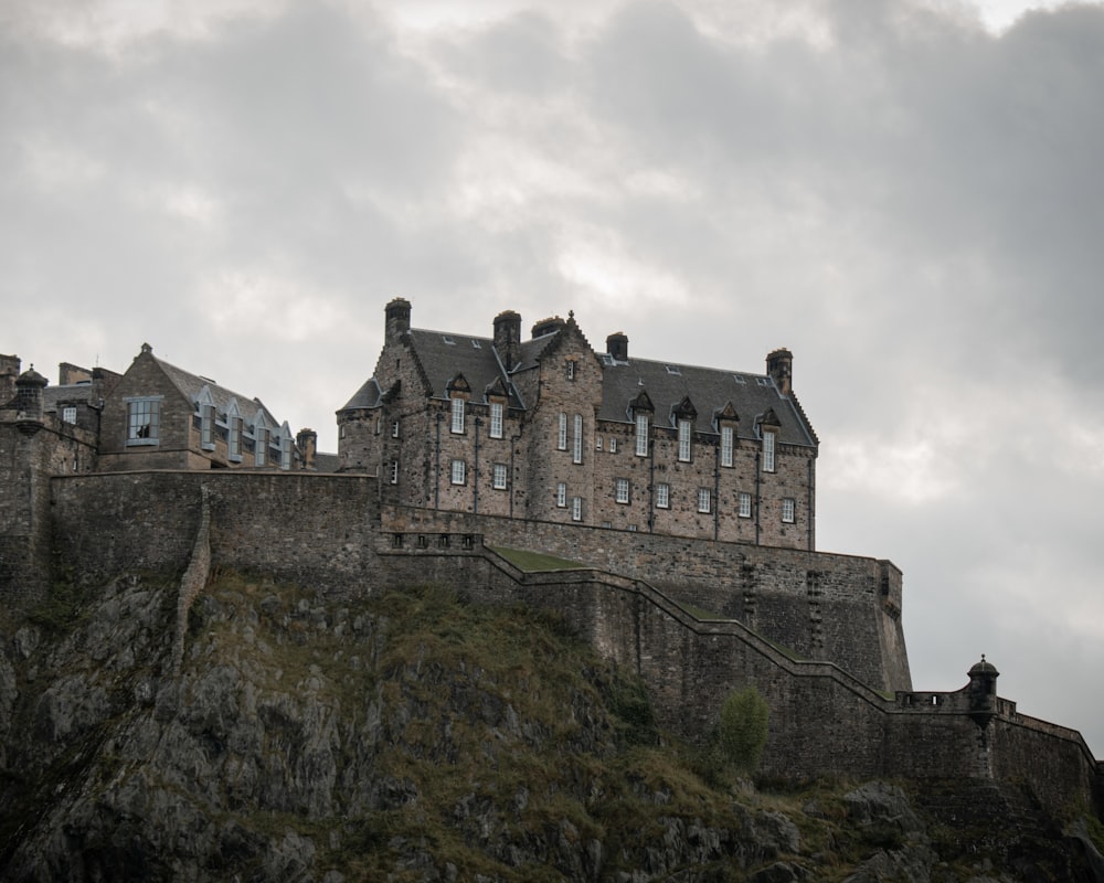 a castle on top of a hill with a cloudy sky