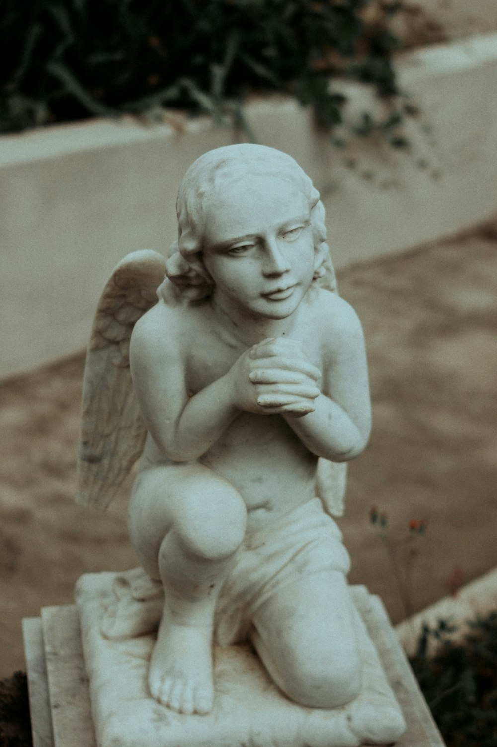 a statue of a kneeling angel holding a cross