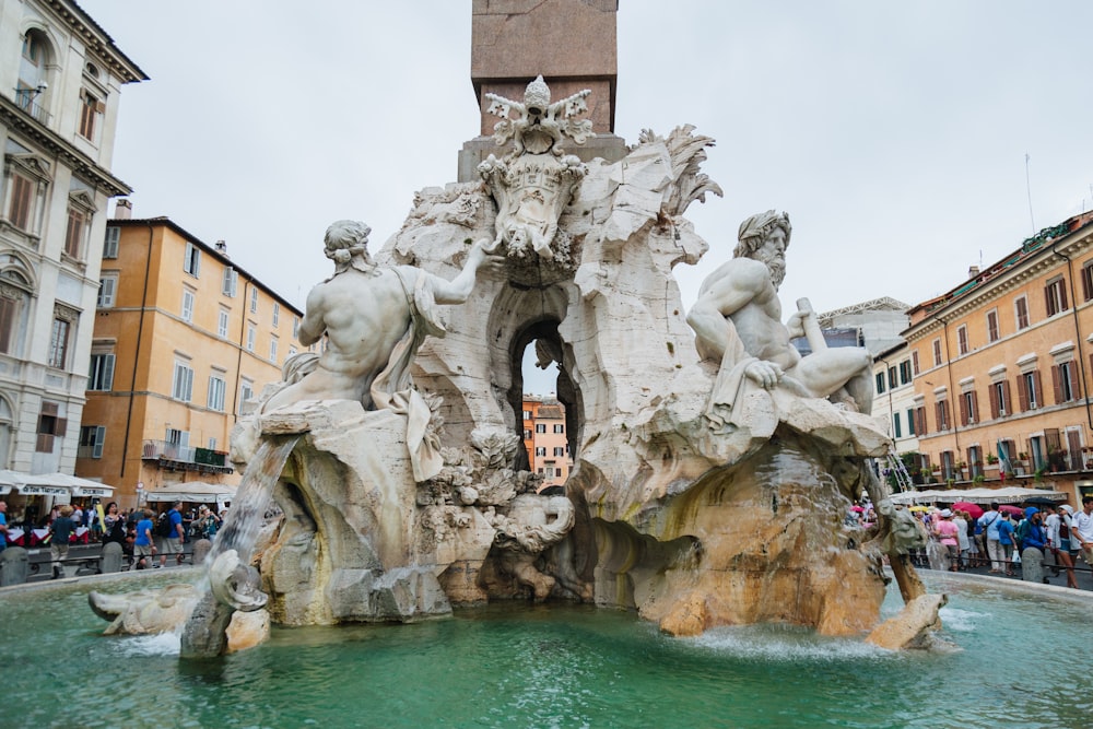 a group of people standing around a fountain