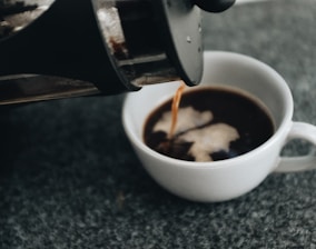 a cup of coffee being poured into it