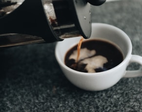 a cup of coffee being poured into it