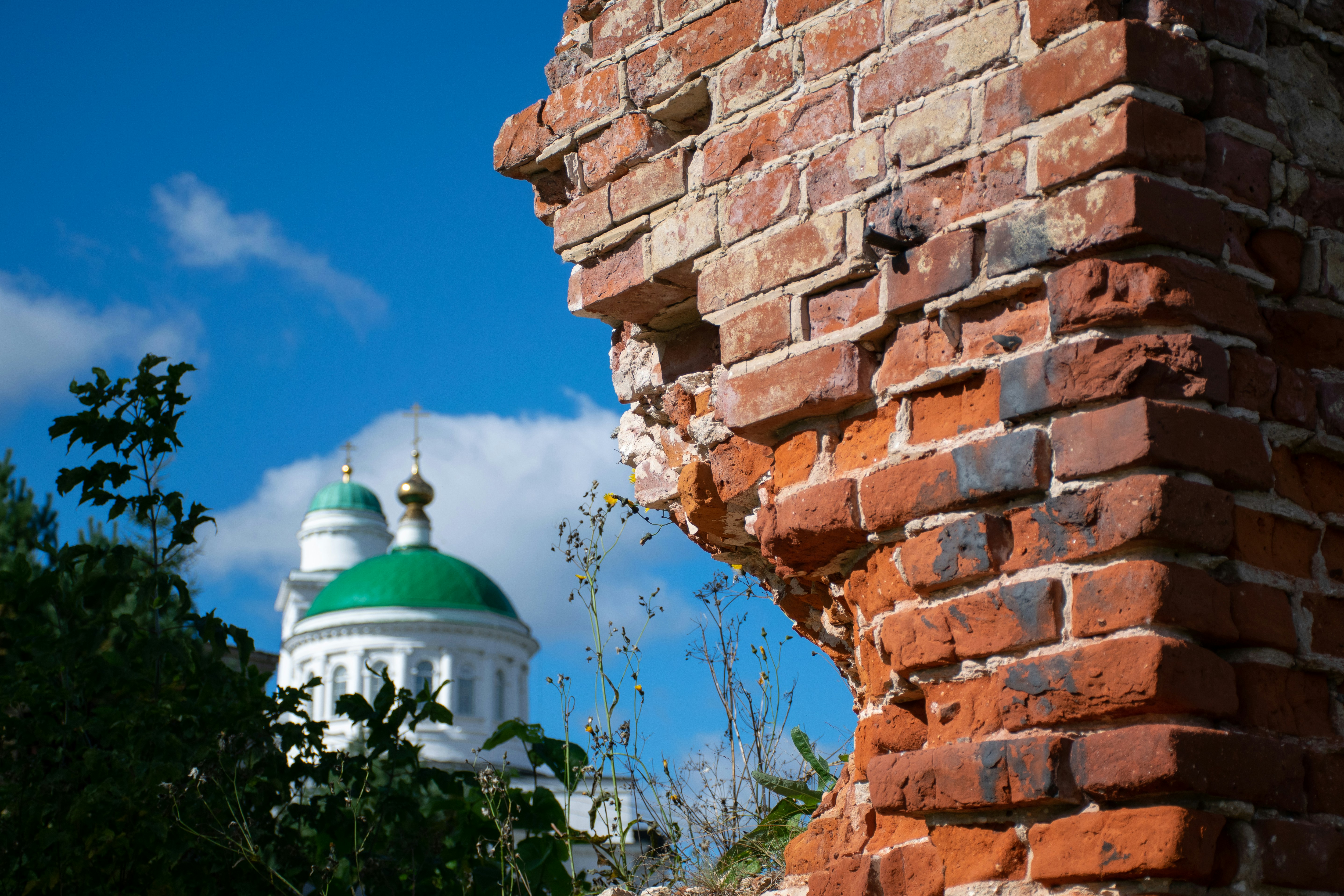 a brick wall with a green and white dome in the background