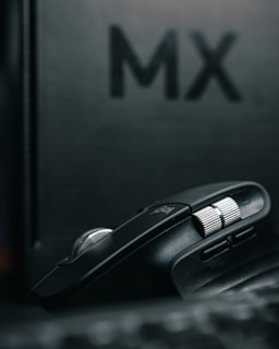 A close-up shot of a sleek mouse racing down a tiny track with blurred cheering crowd in the background.