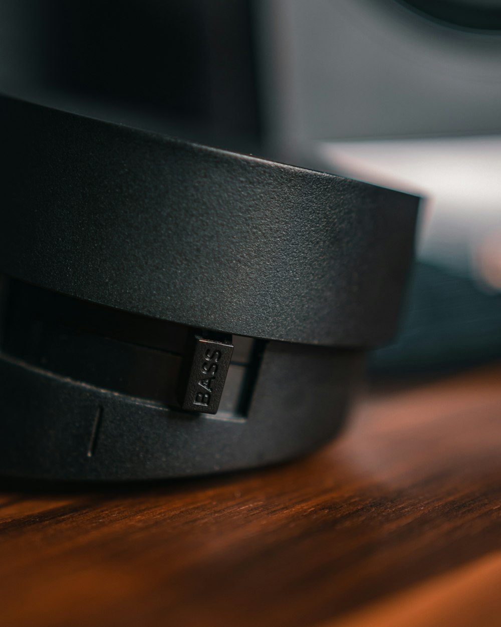 a close up of a black headphone on a wooden table