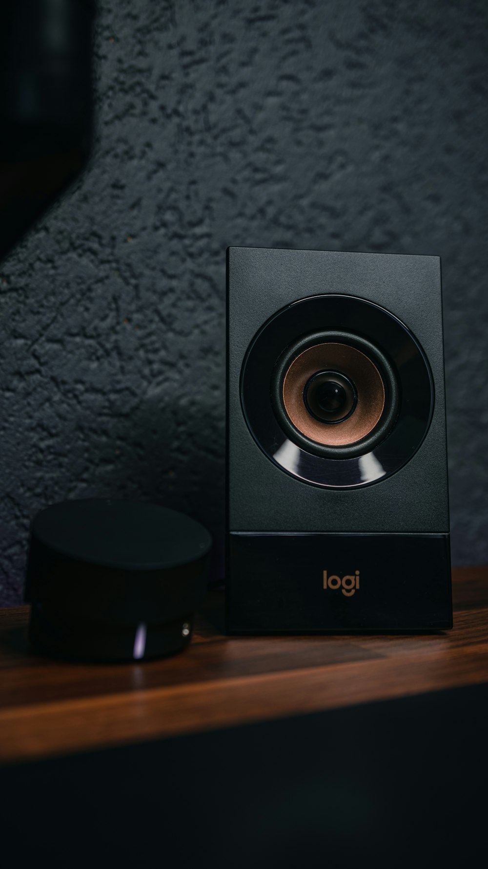 a black speaker sitting on top of a wooden table