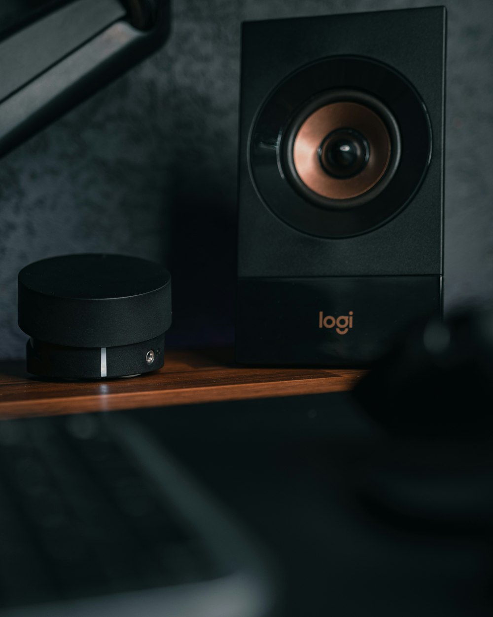 a black speaker sitting on top of a wooden shelf