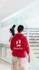 a man in a red hoodie is holding a camera