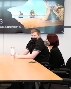 a group of people sitting around a wooden table