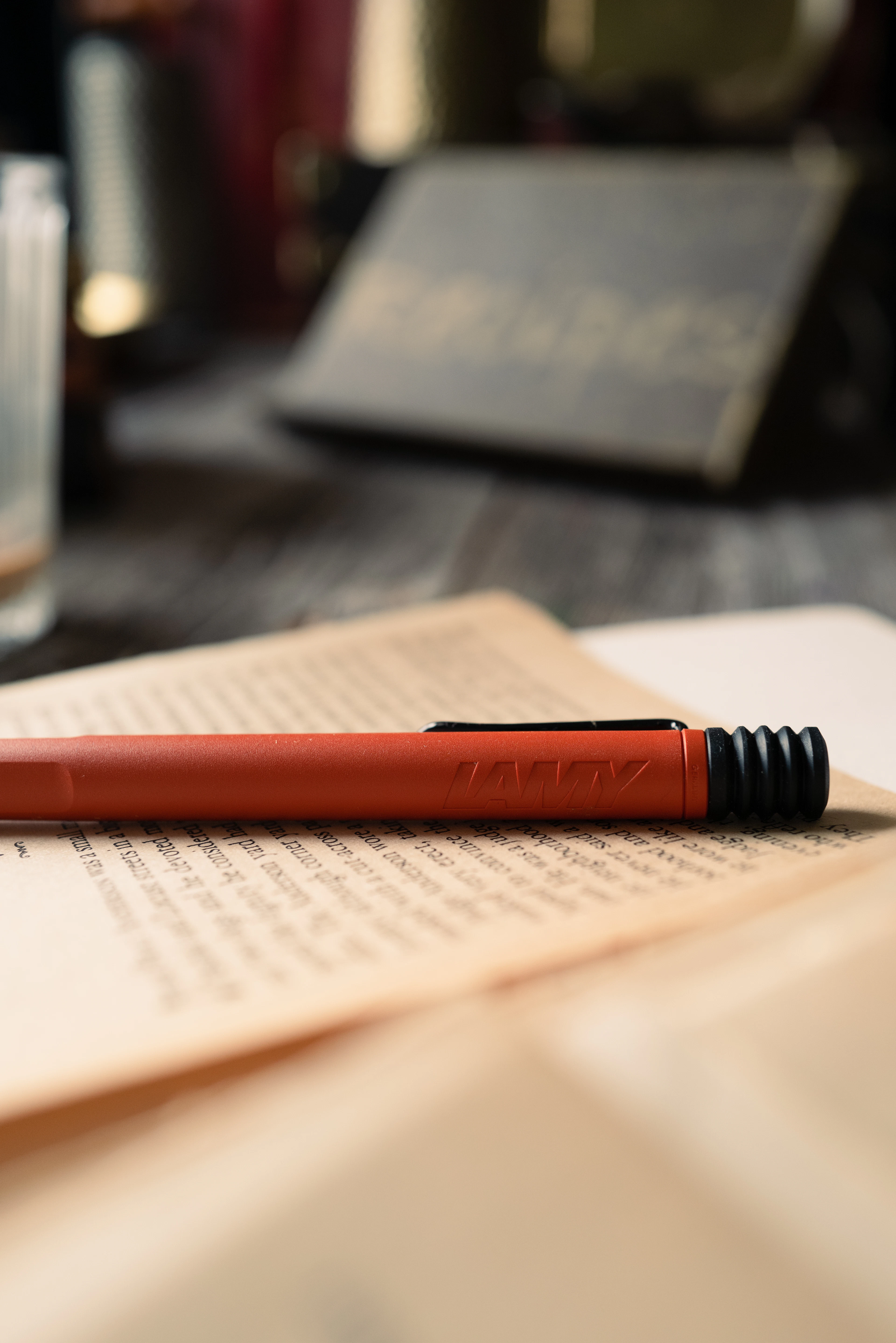 A red pen resting on the printed pages of an open book