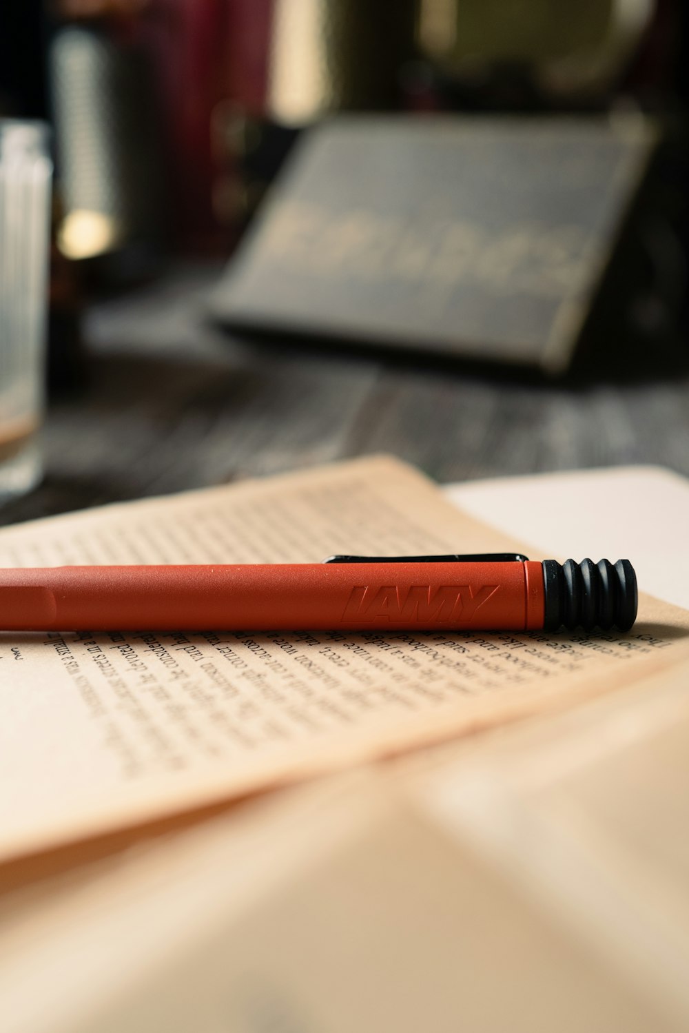 a red pen sitting on top of an open book
