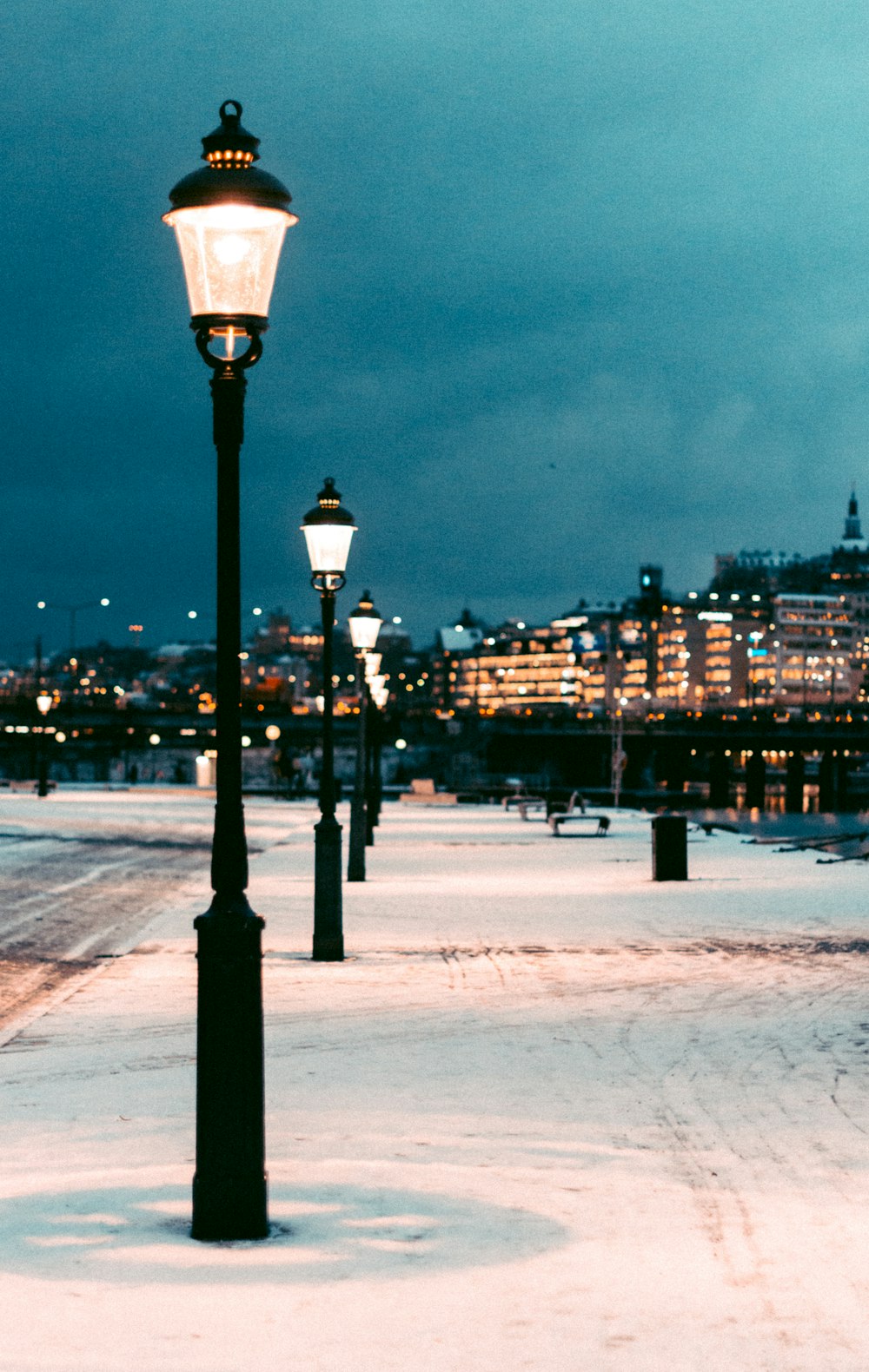 a street light in the middle of a snowy street