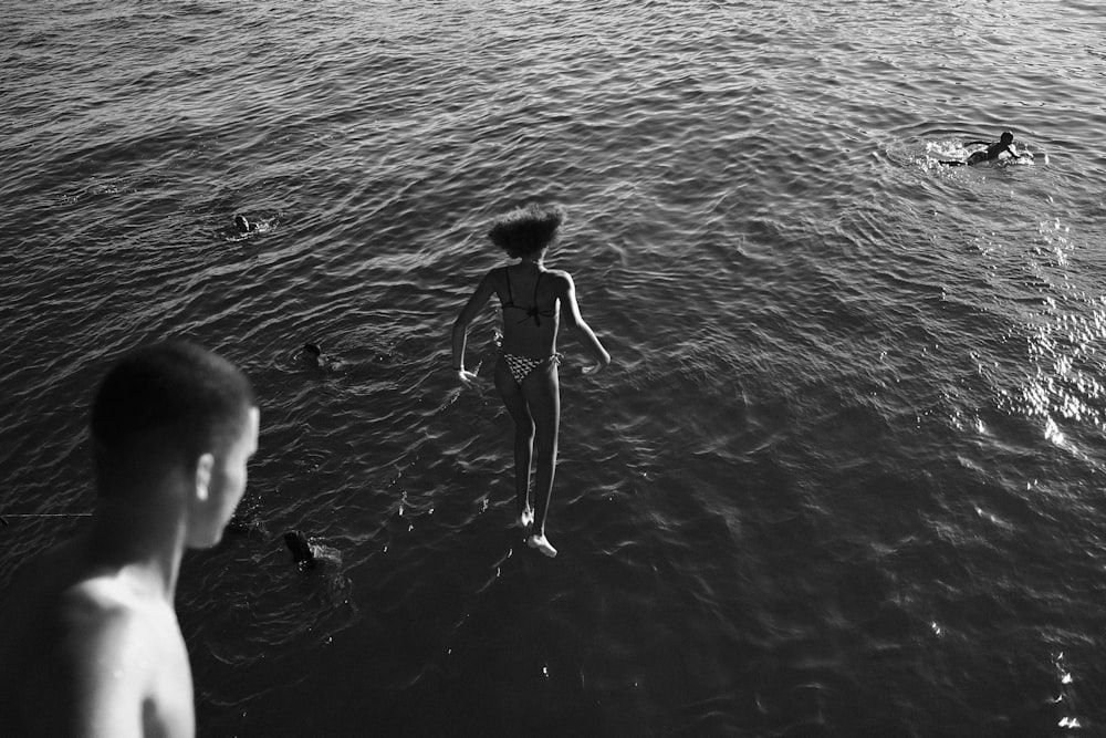Una persona parada en el agua cerca de un cuerpo de agua