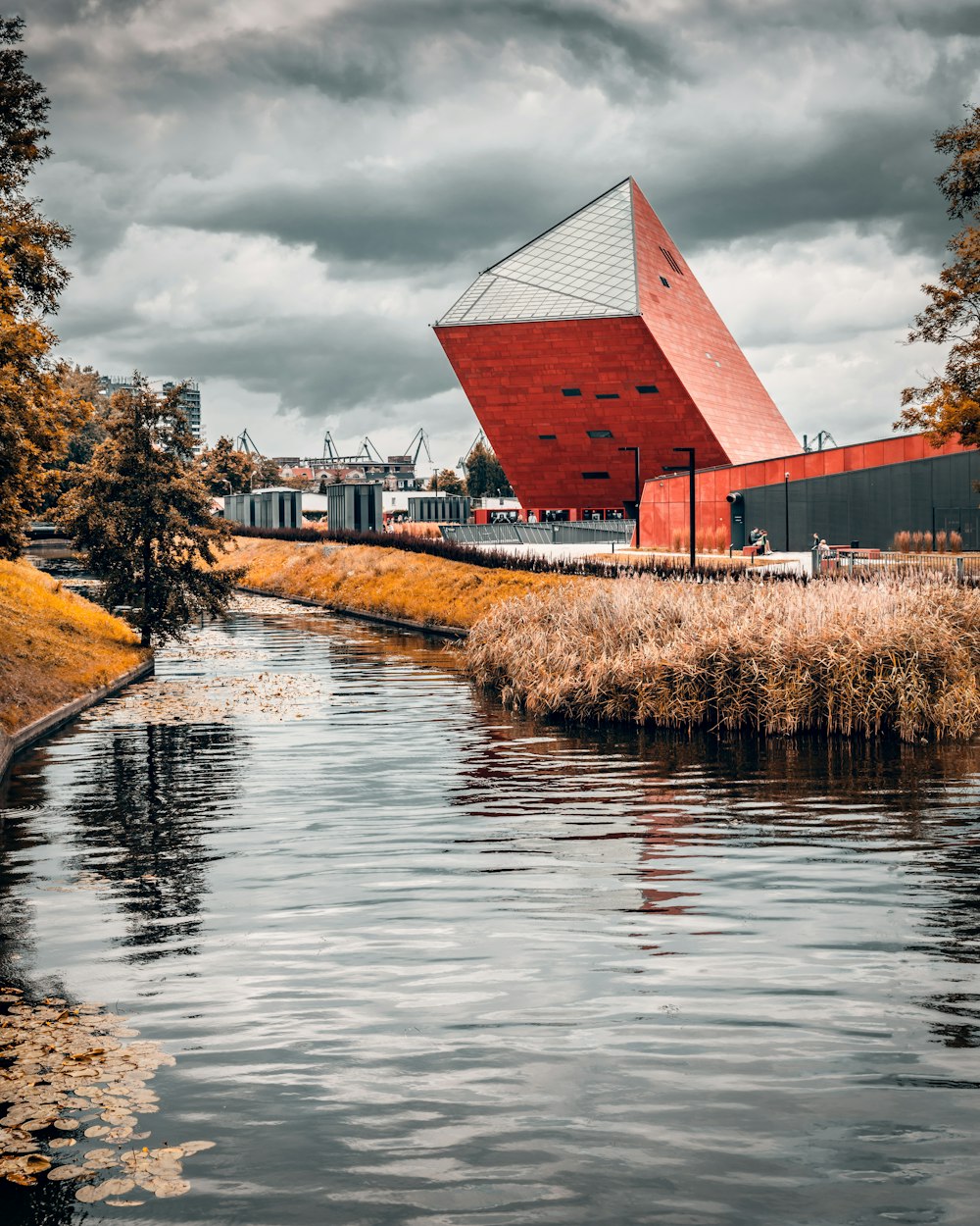 a red building sitting on the side of a river