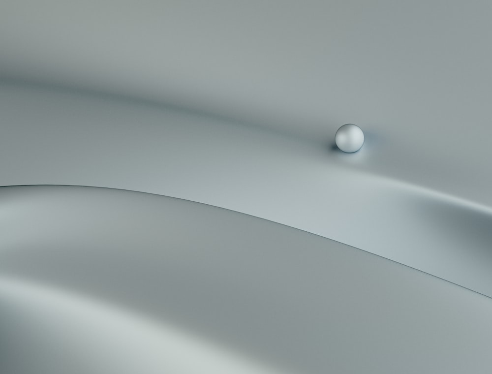 a white ball sitting on top of a gray surface
