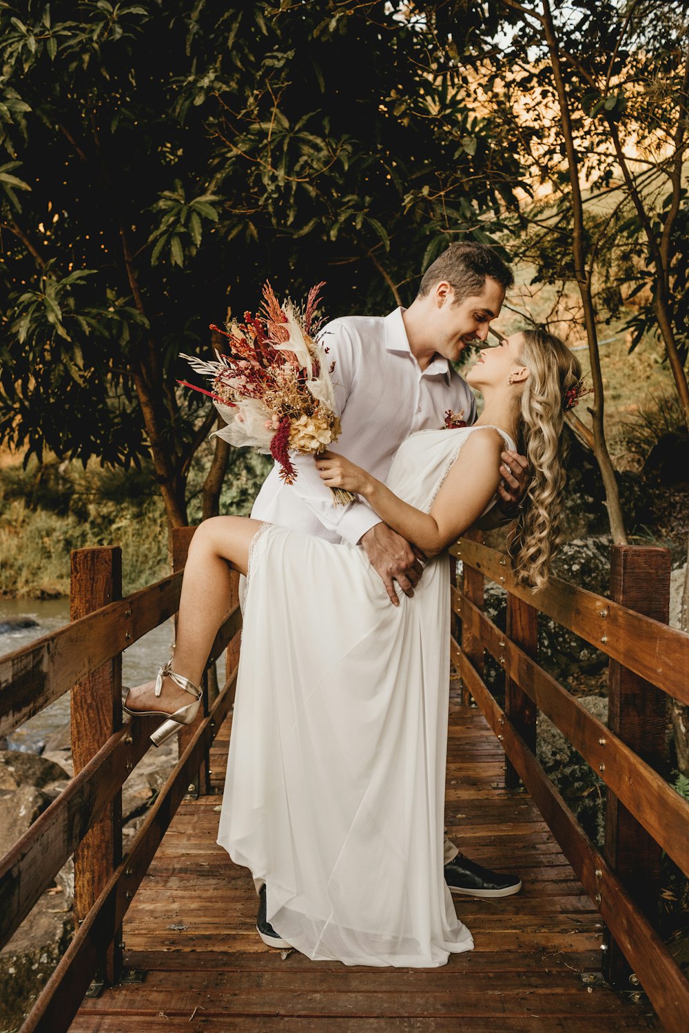 a man and a woman are hugging on a bridge