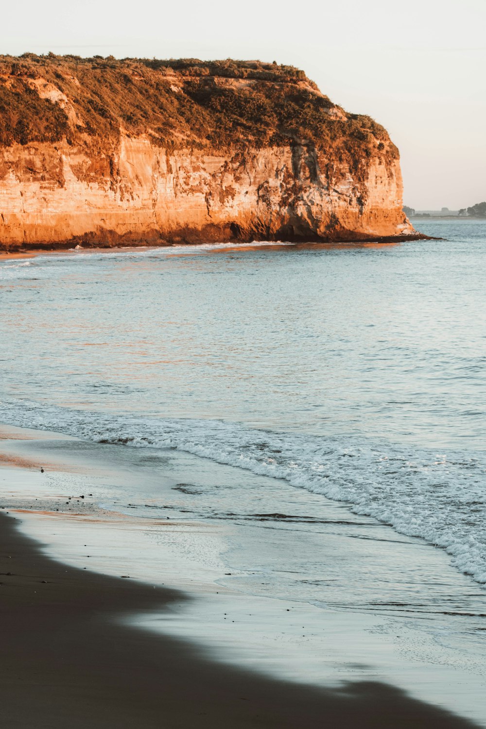 a person walking on a beach next to the ocean