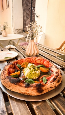 A rustic wooden table with fresh pizza ingredients and herbs from the countryside.