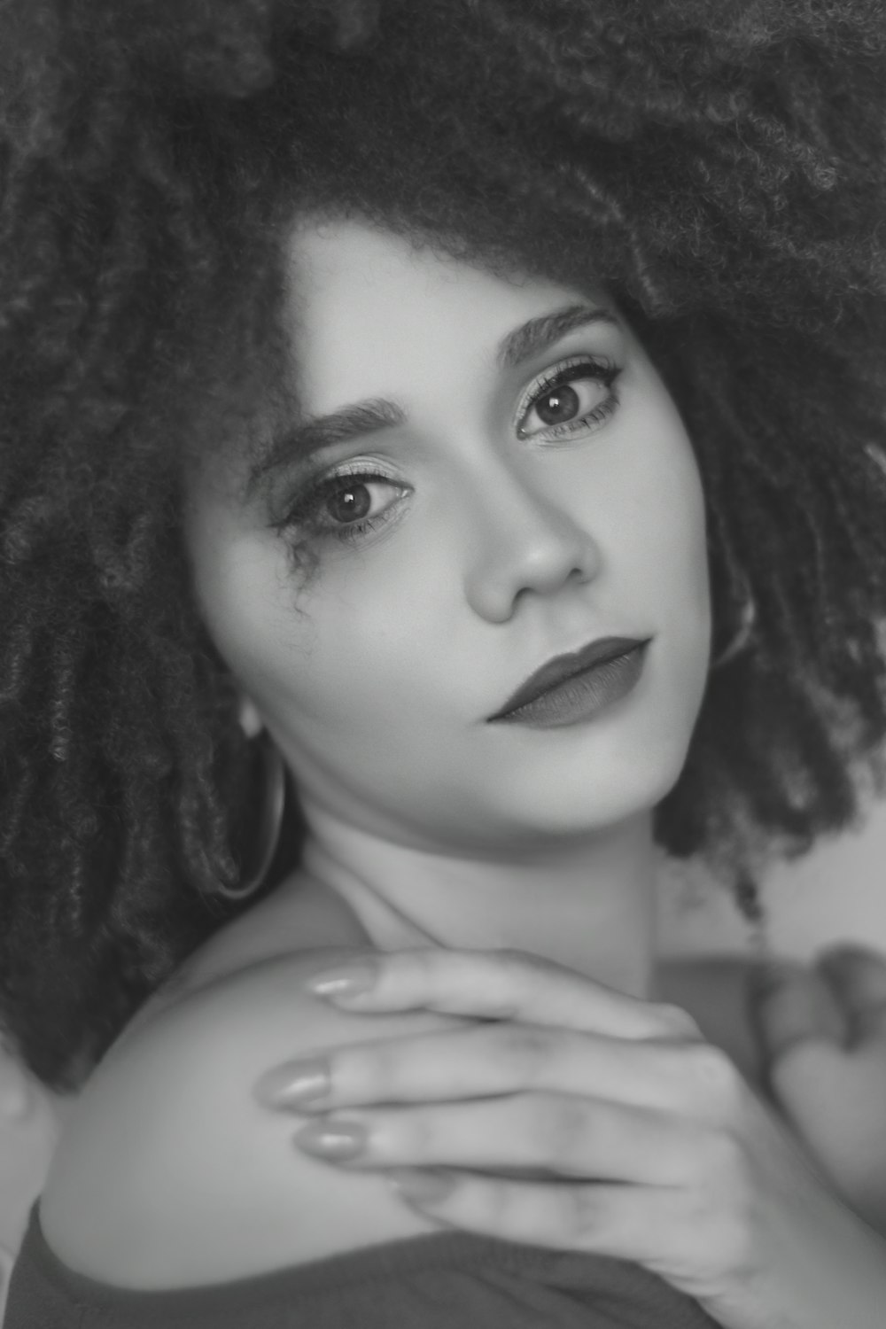 a black and white photo of a woman with curly hair