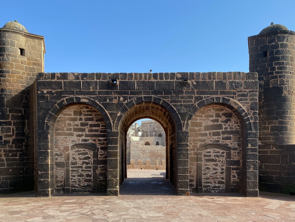 a large brick building with an archway between two towers