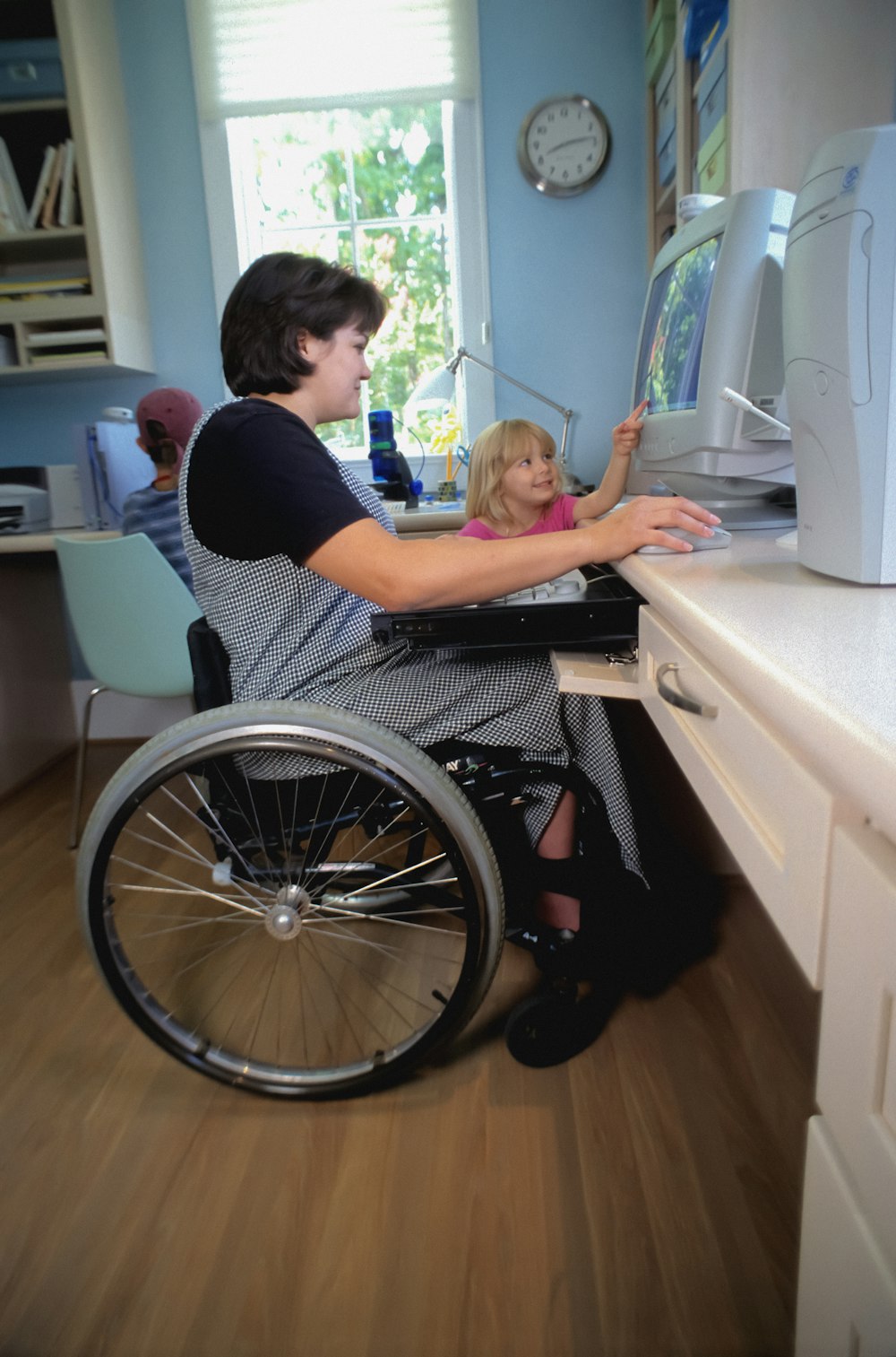 a woman in a wheel chair working on a computer