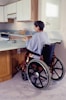 a woman in a wheel chair in a kitchen