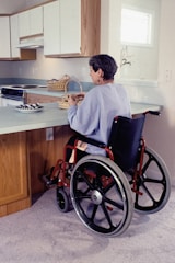 a woman in a wheel chair in a kitchen