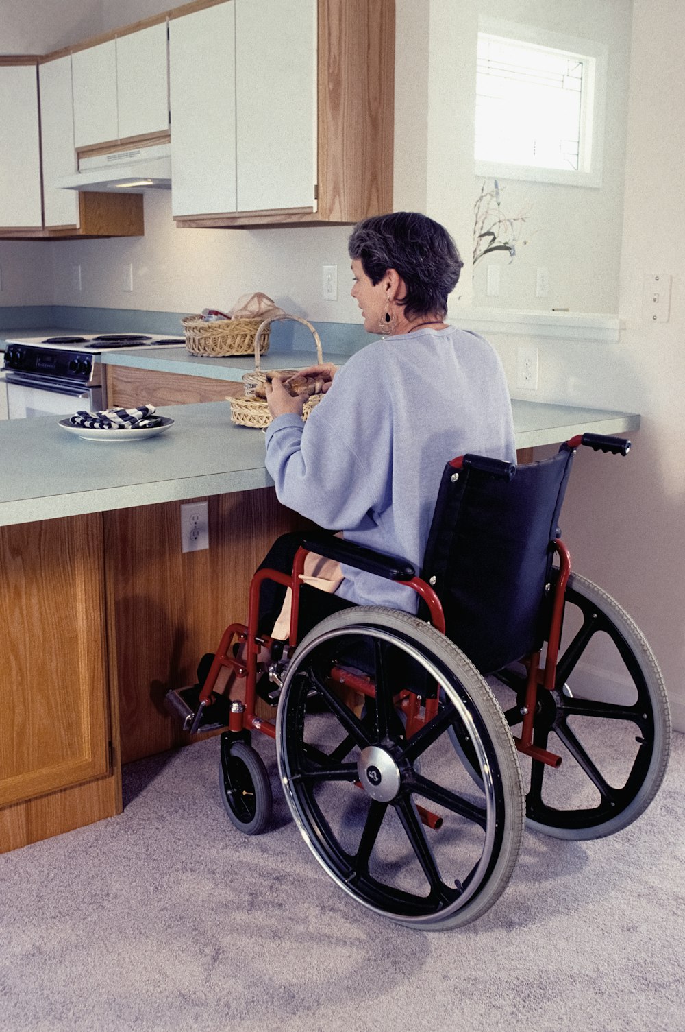 a woman in a wheel chair in a kitchen
