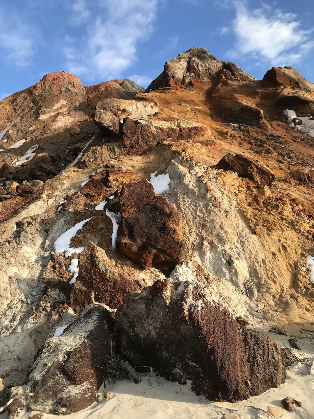 a rocky mountain covered in snow under a blue sky