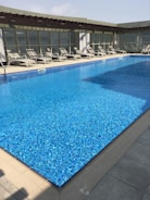 A sparkling swimming pool with sun loungers.