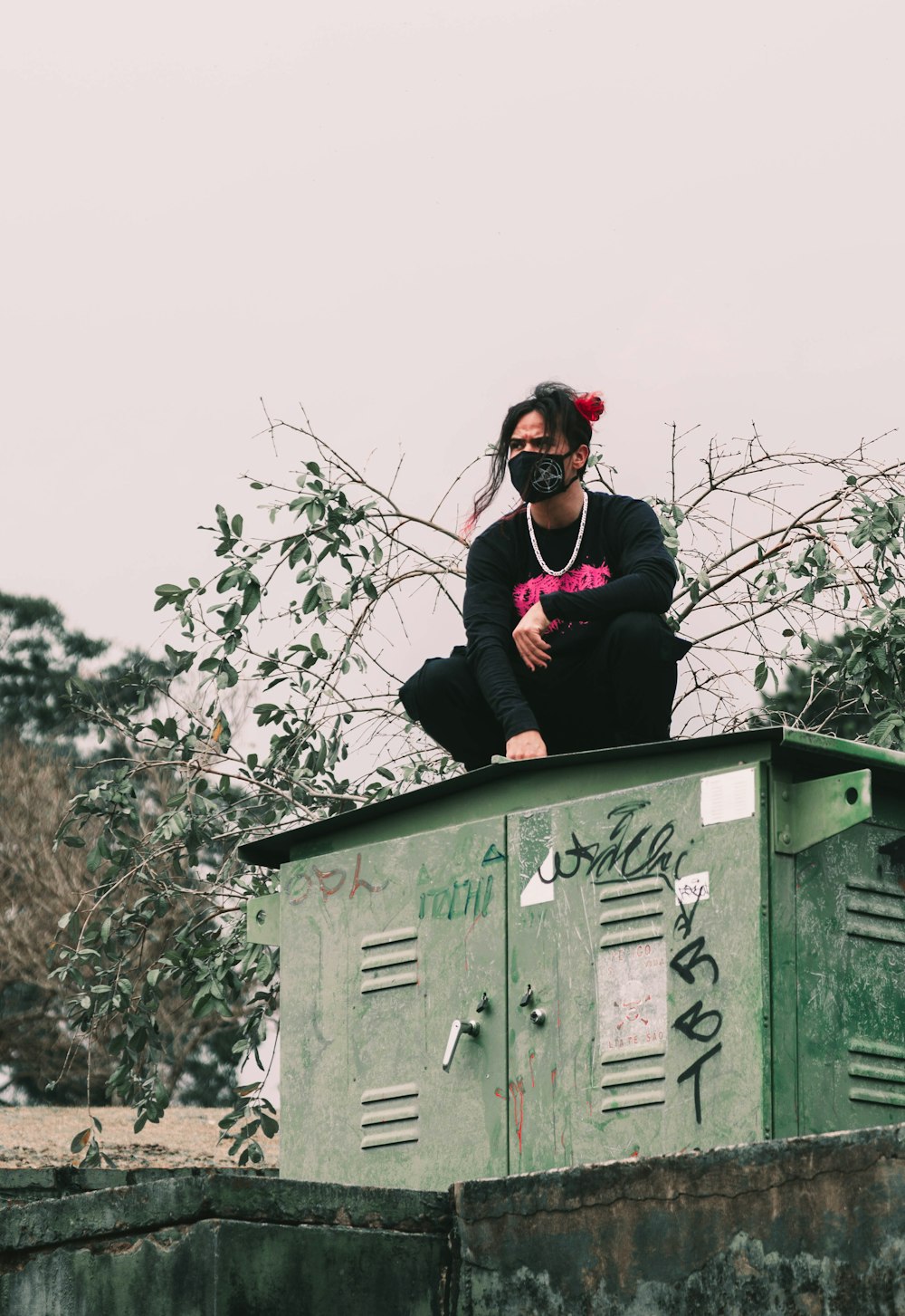 a woman sitting on top of a green box