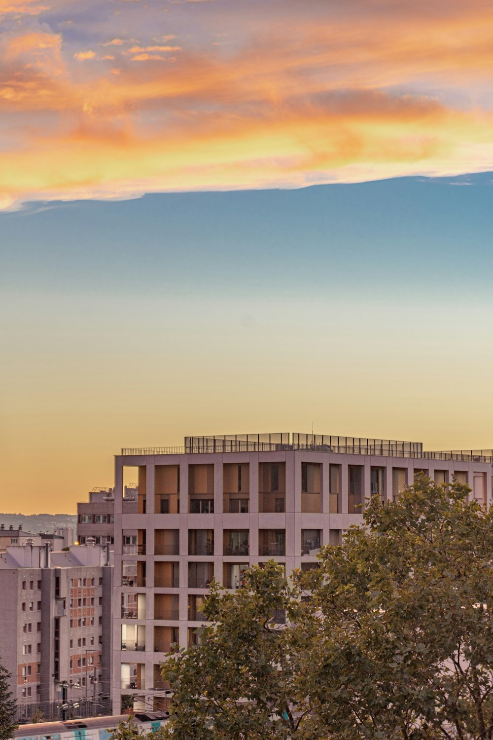 a clock tower towering over a city at sunset