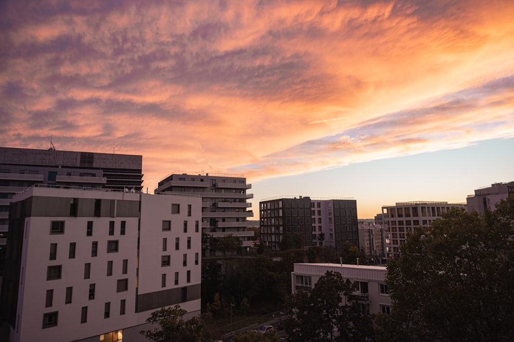 a sunset over a city with tall buildings