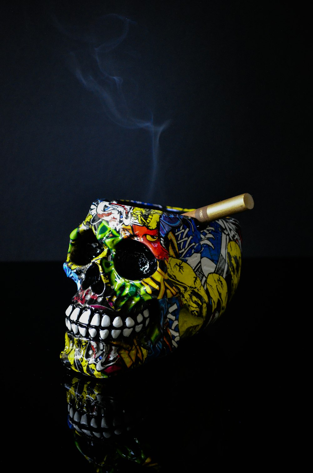 um crânio colorido fumando um cigarro em uma superfície preta