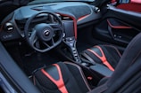 the interior of a sports car with red and black trim