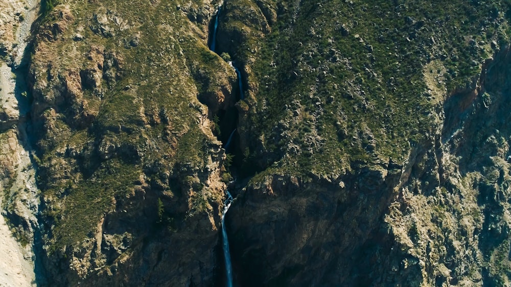 an aerial view of a waterfall in the mountains