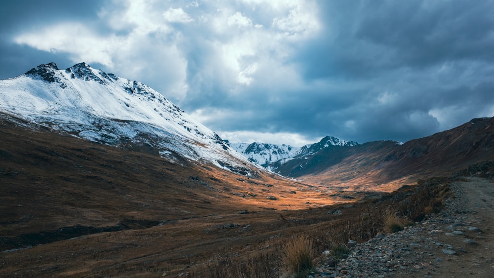 a dirt road with a mountain in the background