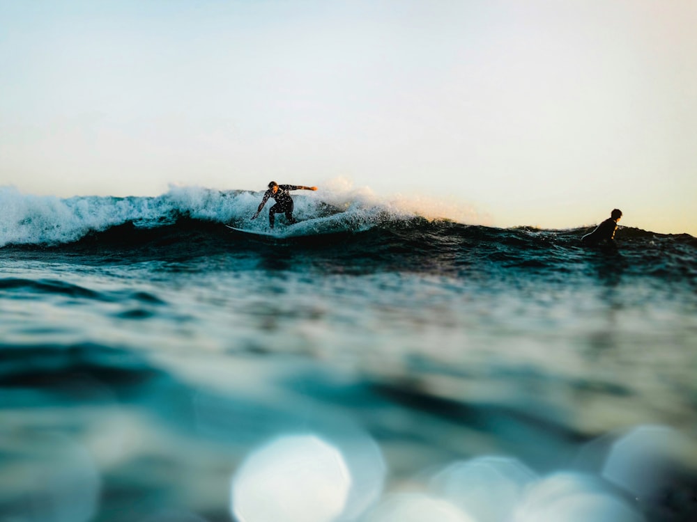 a man riding a wave on top of a surfboard