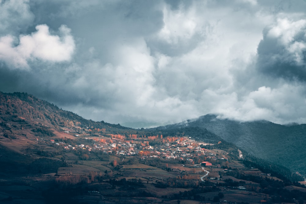 a view of a village on a hill under a cloudy sky