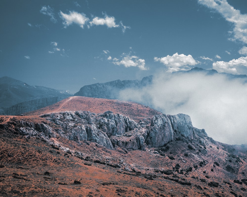 a mountain range with clouds and mountains in the background