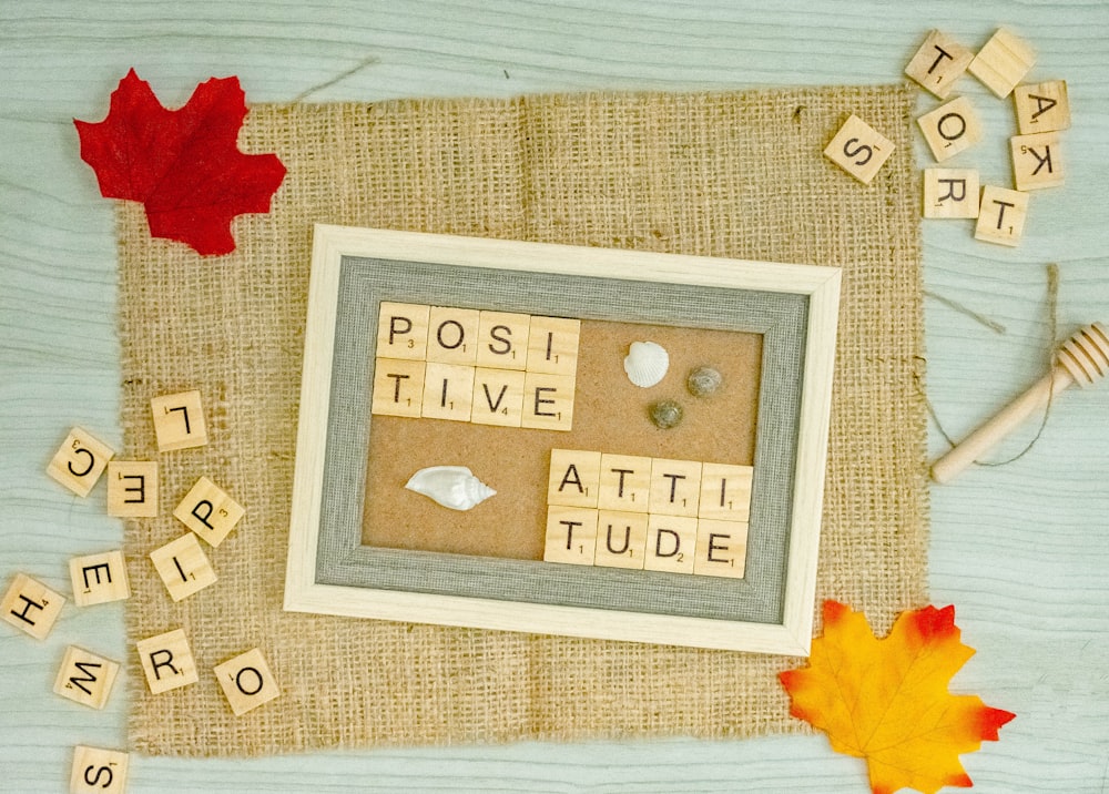 a picture frame surrounded by scrabbles and autumn leaves