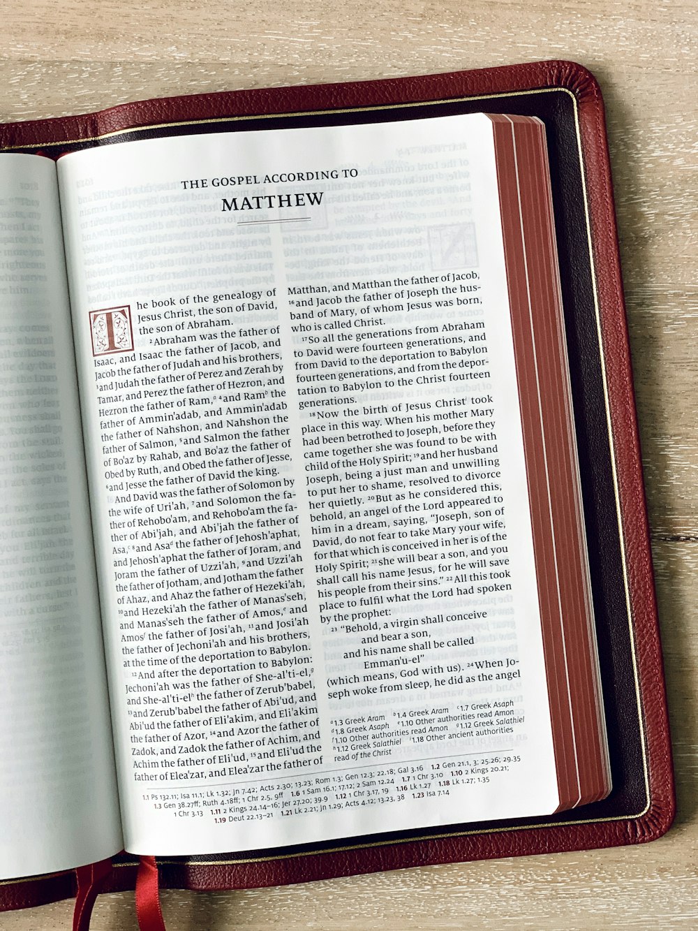 an open book on a table with a red ribbon