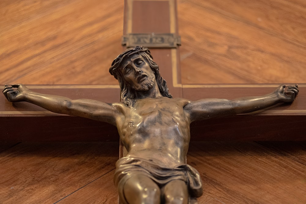 Eine Bronzestatue von Jesus auf einem Holzkreuz