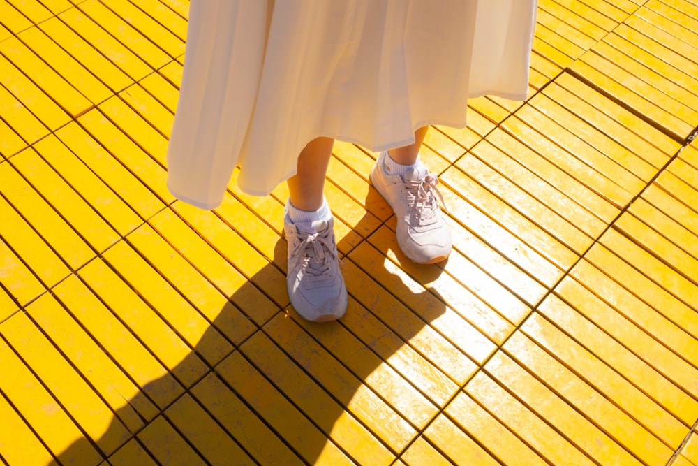 a person standing on a yellow tiled floor