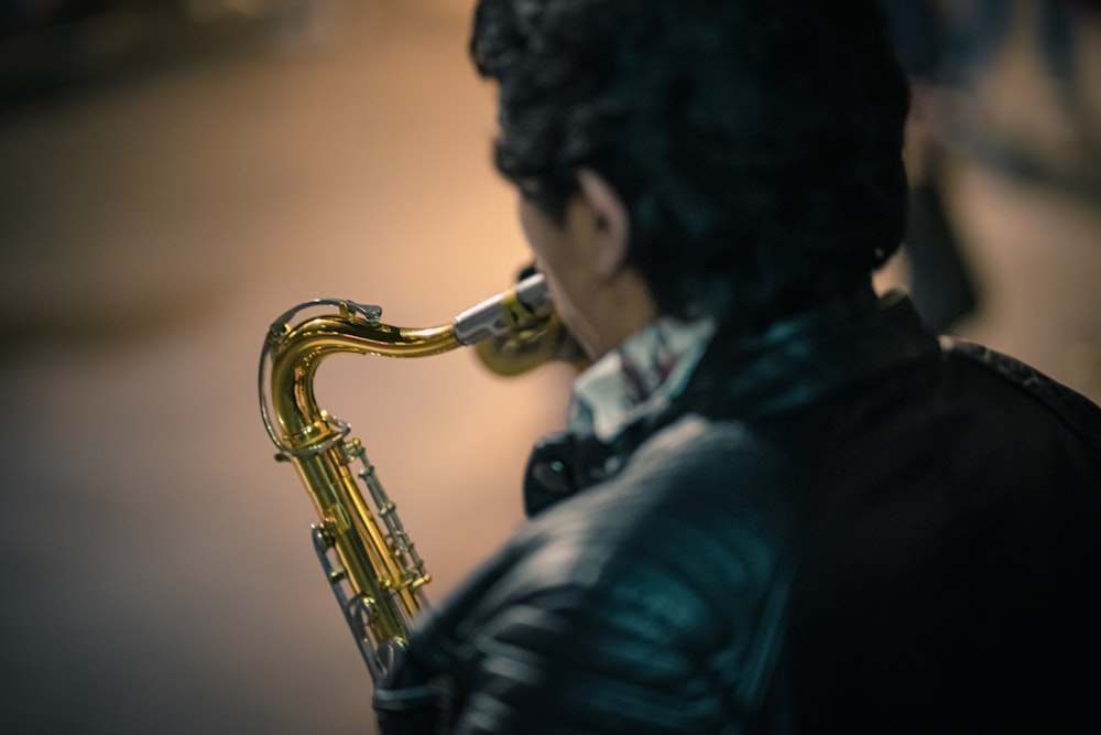 a man in a leather jacket playing a saxophone