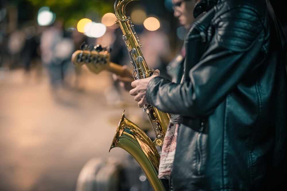 a man playing a saxophone on a city street