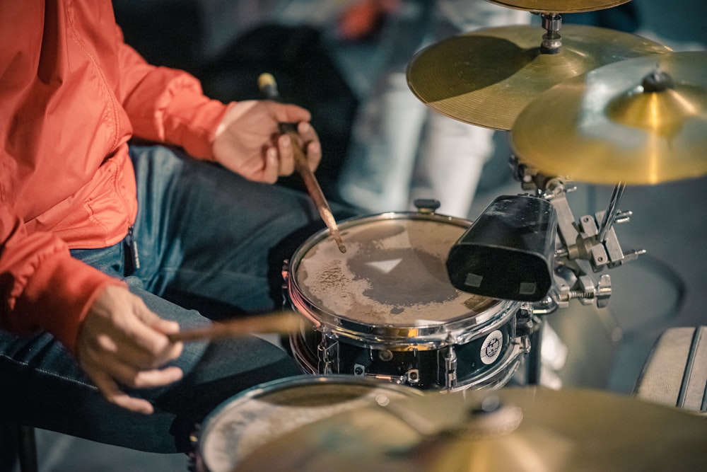 a man sitting in front of a drum set