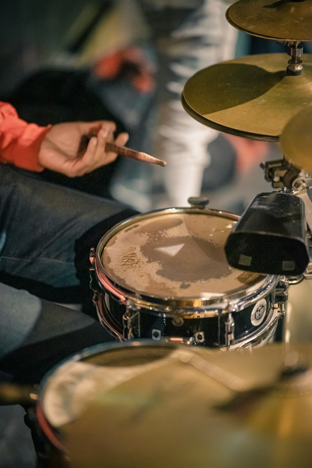 a man sitting in front of a drum set